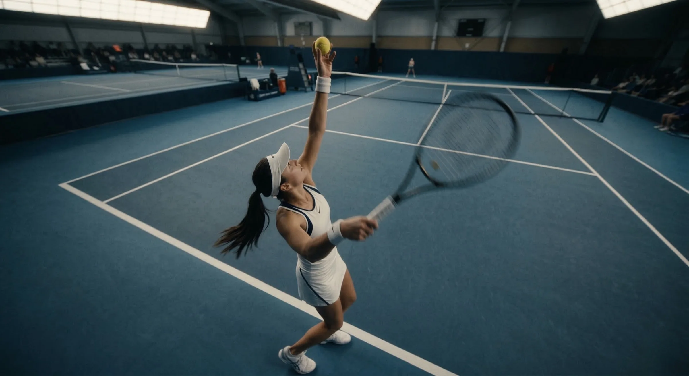 TAC Tennis Gym インドアテニスコートでのサーブシーン - 室内テニス場